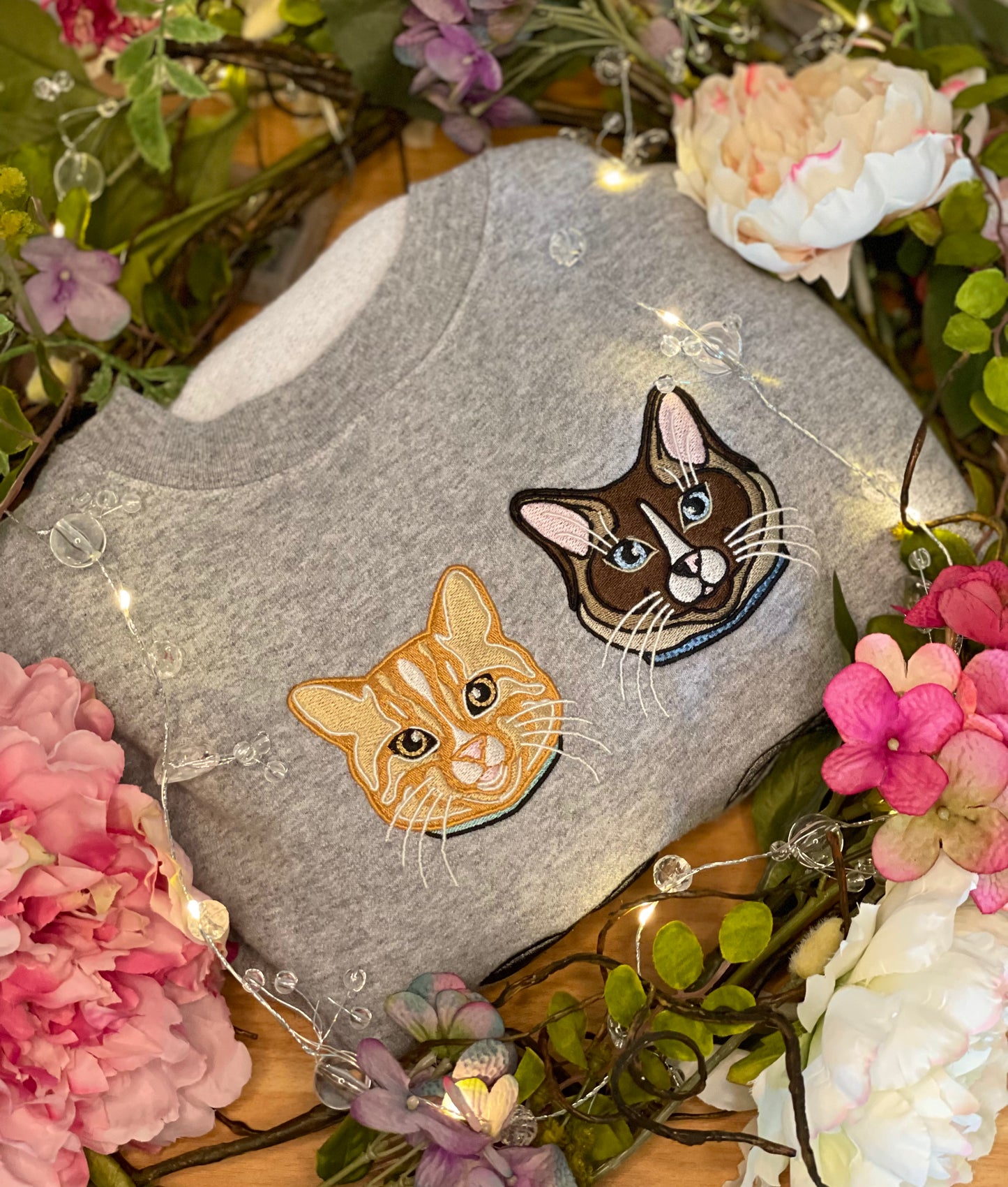 Orange Cat personalized Sweatshirt, embroidered orange cat left chest 4x4 inches. Available in sizes S-3XL. Available crew colors include pigment pink, forest green and baby blue. Shown is an orange cat and Ragdoll call embroidered on a grey sweathirt.