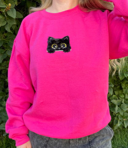 This sweatshirt crewneck is Dark Neon Pink embroidered with a super soft black fluffy (faux) fur kitty on the center front chest. Kitty looks like she is poking out of a pocket (Not a real pocket) with her big harvest gold eyes staring back at you. Unisex fit, mid-weight fabric, Material: 50% cotton / 50% polyester Blend.