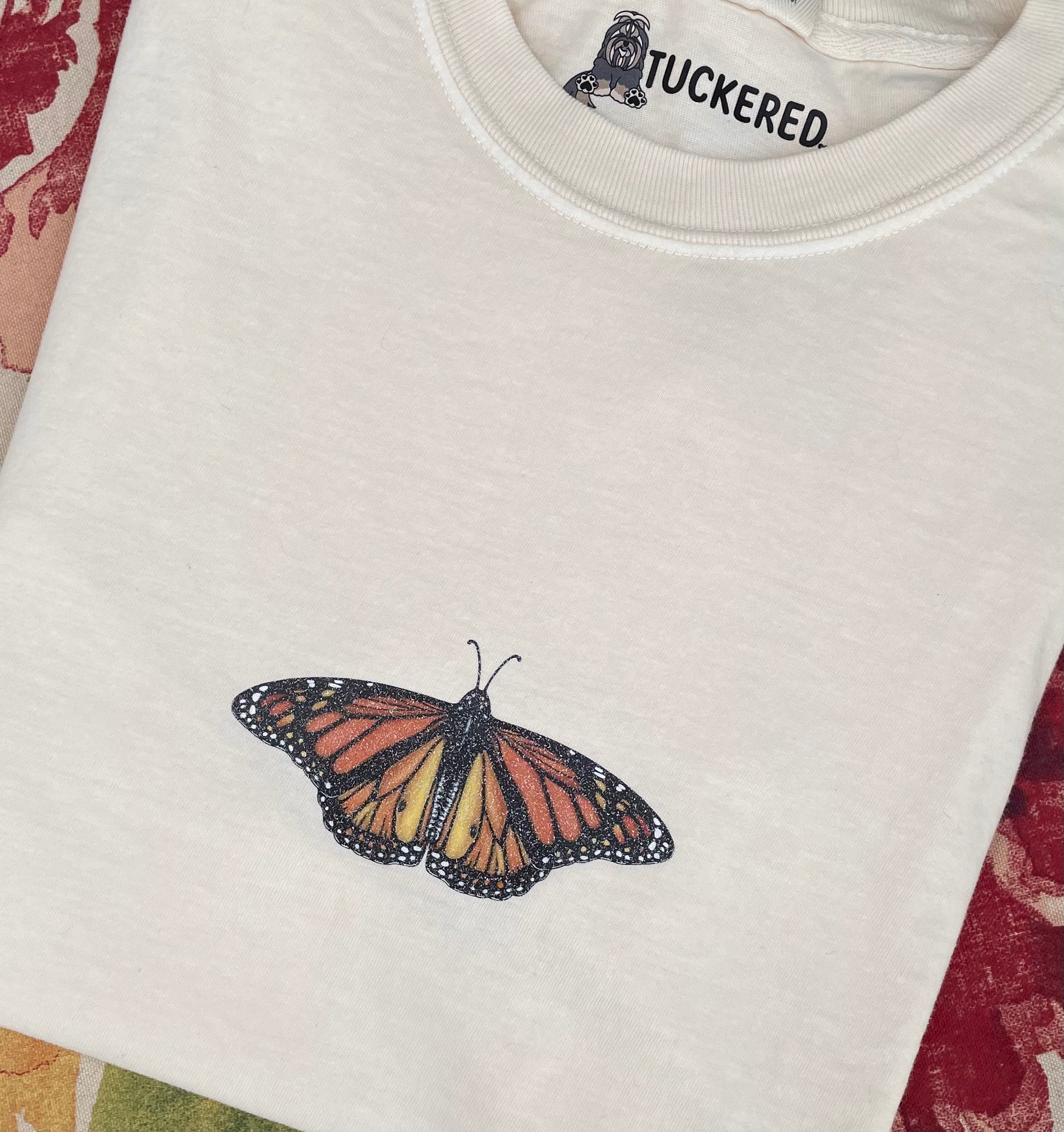 This T-shirt design has a dainty sparkly Monarch butterfly on the center front chest. 100% heavy cotton, garment dyed with a faded look and relaxed fit, ivory (ivory is slightly transparent). Sizes available: small, medium, large, XL, 2XL, 3XL, 4XL. 5XL is a Gildan T-Shirt color and texture varies slightly.