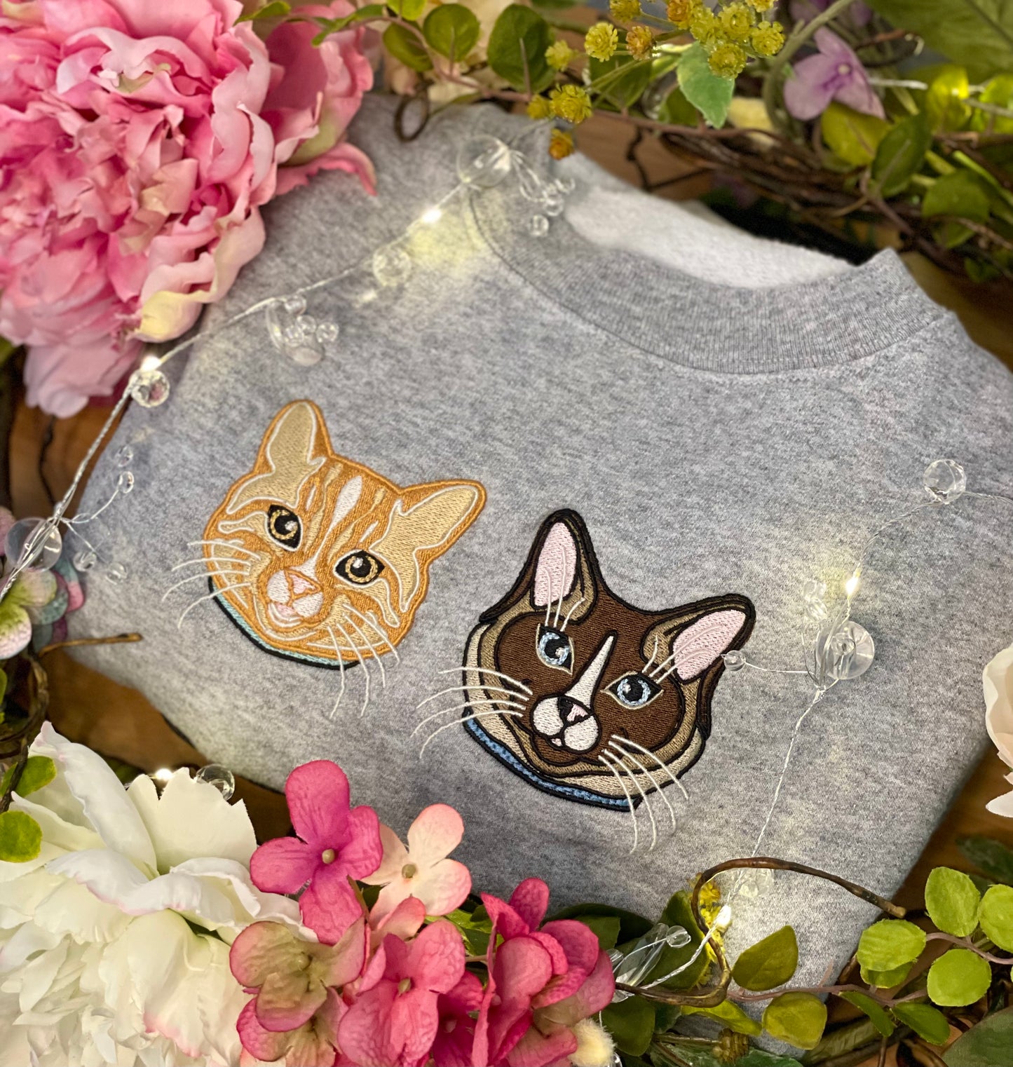 Orange Cat personalized Sweatshirt, embroidered orange cat left chest 4x4 inches. Available in sizes S-3XL. Available crew colors include pigment pink, forest green and baby blue. Shown are both designs of an orange cat and ragdoll cat embroidered on a gray sweatshirt. 