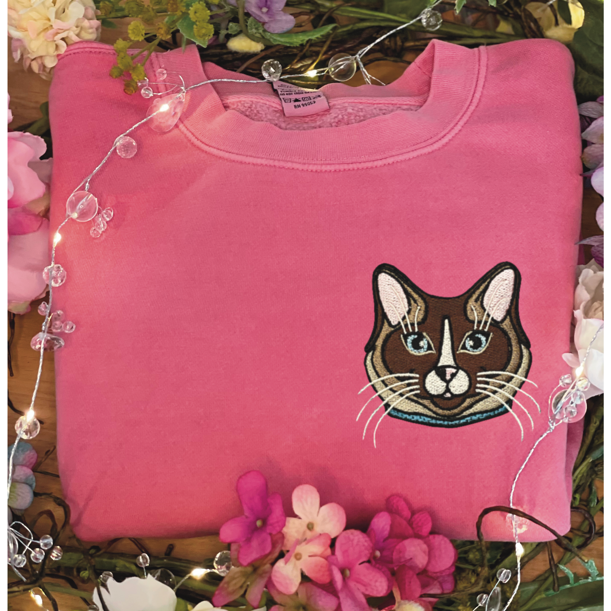 Ragdoll, Snowshoe, Siamese Cat embroidered on a crewneck sweatshirt color pigment pink design is 4x4 inches left chest. Available in sizes S-3XL