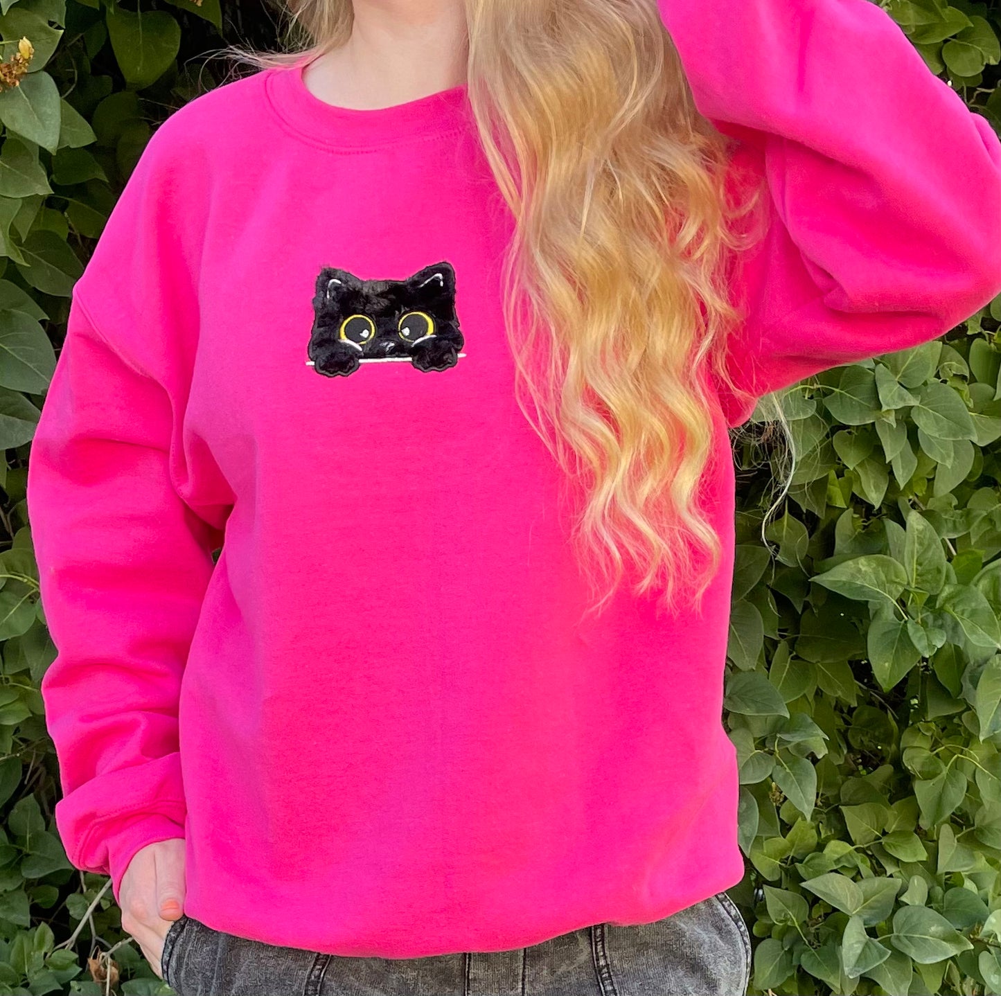 This sweatshirt crewneck is Dark Neon Pink embroidered with a super soft black fluffy (faux) fur kitty on the center front chest. Kitty looks like she is poking out of a pocket (Not a real pocket) with her big harvest gold eyes staring back at you. Unisex fit, mid-weight fabric, Material: 50% cotton / 50% polyester Blend.