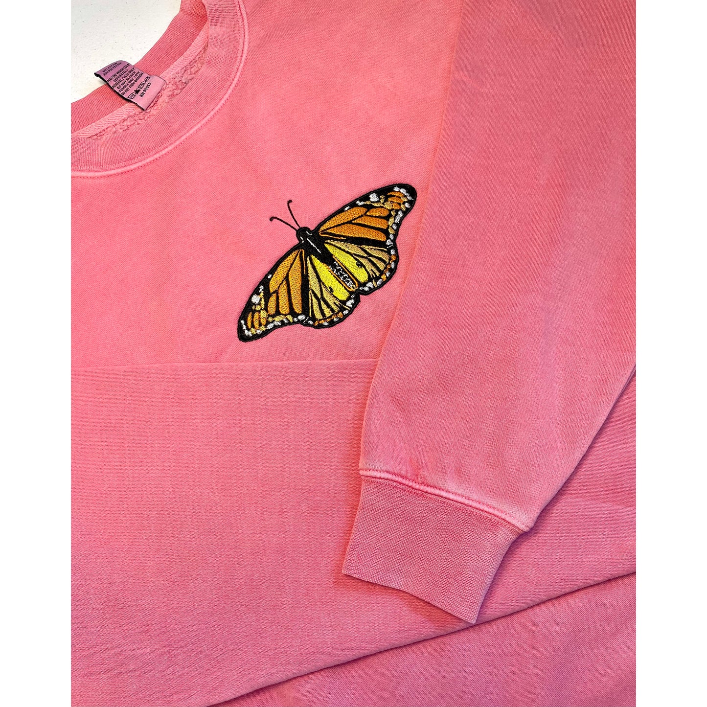 These crewneck sweatshirts are pigment dyed which adds a beautiful unique look. The crewnecks are embroidered with high quality thread that leaves a beautiful sparkle when it hits the sun. Embroidered with a beautiful monarch butterfly. Center chest embroidered graphic, unisex fit, mid-weight fabric, material: 80% cotton/ 20% polyester blend, colors: pink, light blue, or forrest green. Sizes S, M, L, XL, 2XL, 3XL available.