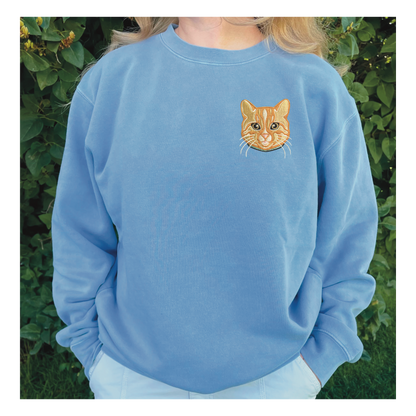 Orange Cat personalized Sweatshirt, embroidered orange cat left chest 4x4 inches. Available in sizes S-3XL. Available crew colors include pigment pink, forest green and baby blue. Shown is an orange cat embroidered on a baby blue sweatshirt. 