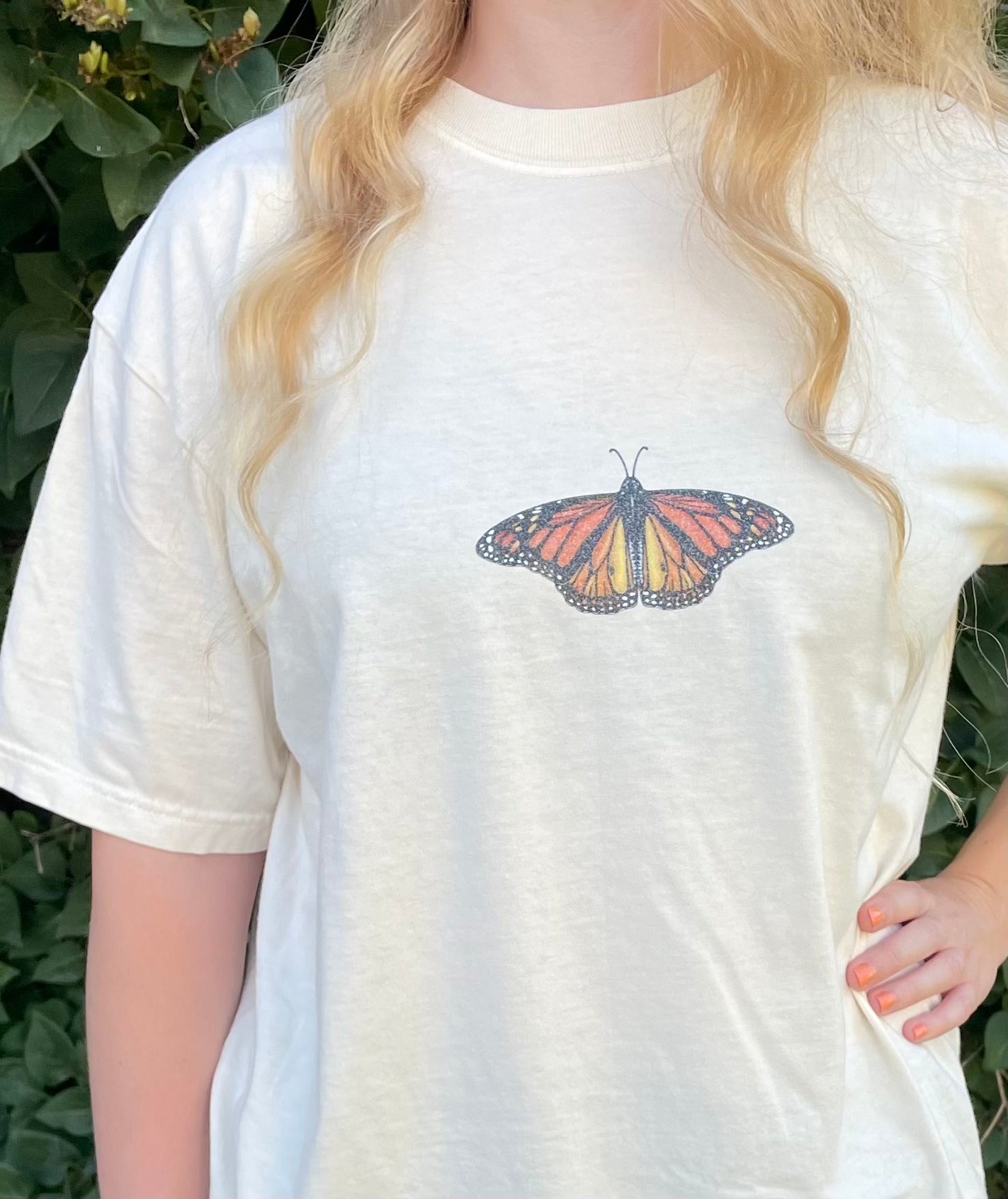 This T-shirt design has a dainty sparkly Monarch butterfly on the center front chest. 100% heavy cotton, garment dyed with a faded look and relaxed fit, ivory (ivory is slightly transparent). Sizes available: small, medium, large, XL, 2XL, 3XL, 4XL. 5XL is a Gildan T-Shirt color and texture varies slightly.