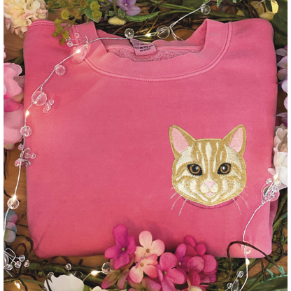 Cream/Tan Tabby Cat Embroidered Crewneck Sweatshirt. Design is 4x4 inches left chest. Available in sizes S-3XL on Pigment Pink Sweatshirt. 