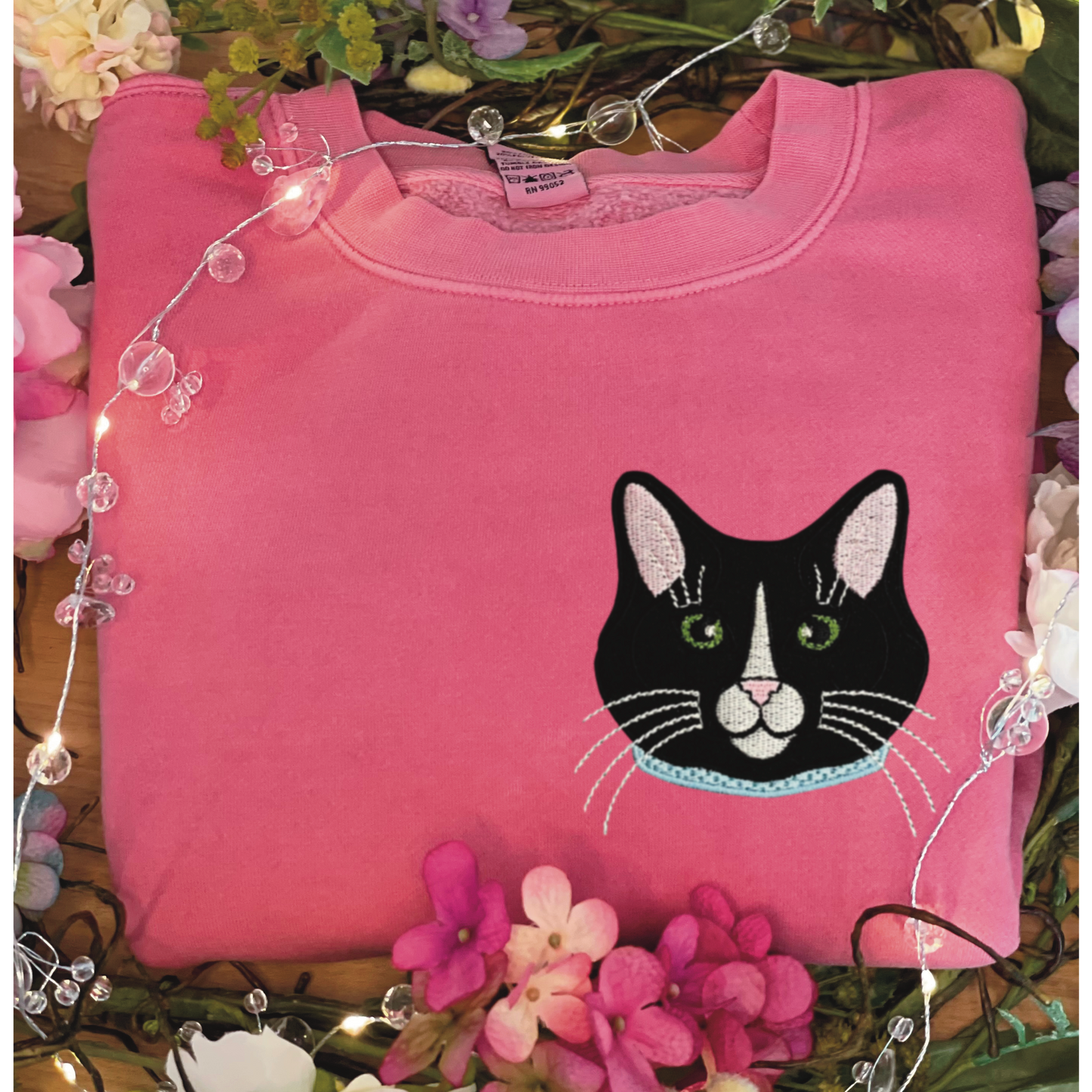 Tuxedo Black and White Cat Embroidered Crewneck Sweatshirt. Design is 4x4 inches left chest. Available in sizes S-3XL on Pigment Pink Sweatshirt. 